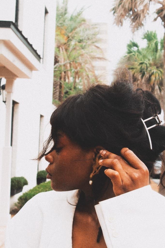 Gold ear cuff and hair claw with palm trees and white architecture