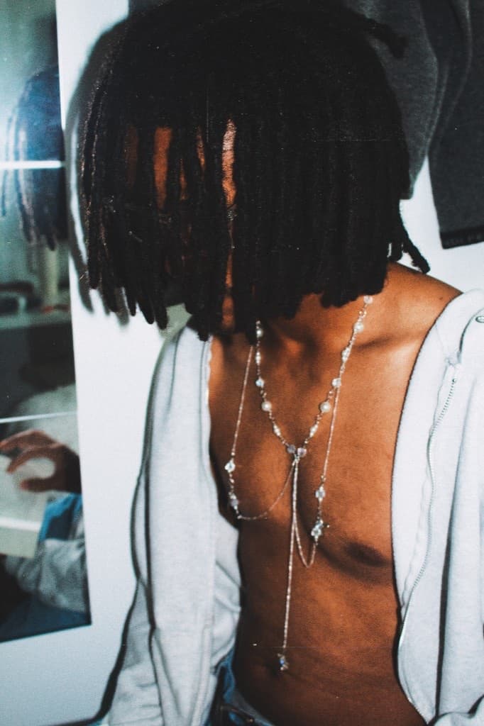 Silver chain necklace with crystal stations worn over an open hoodie