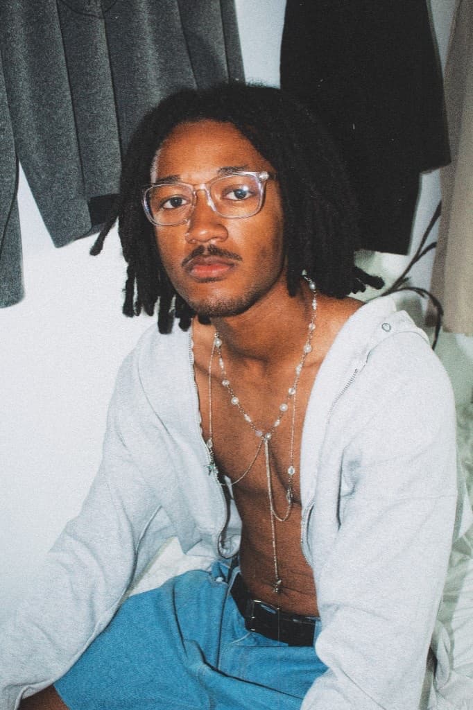 Seated portrait in glasses wearing the layered silver necklace