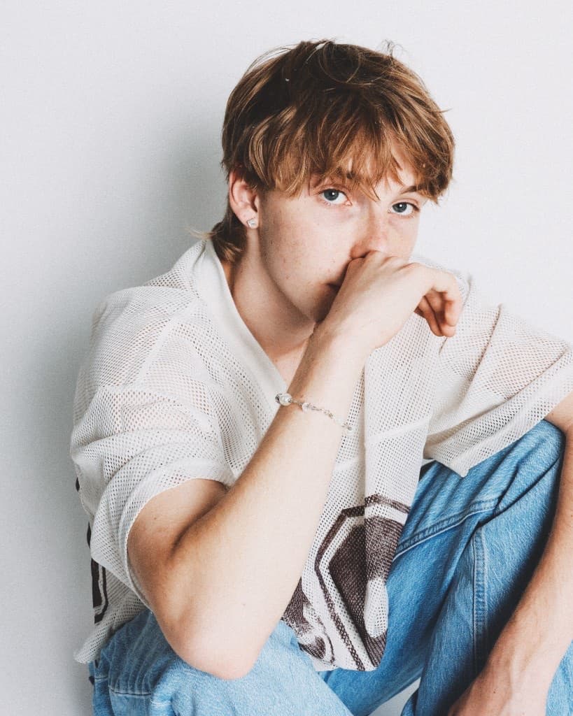 Candid seated frame with the pearl bracelet, hand over mouth