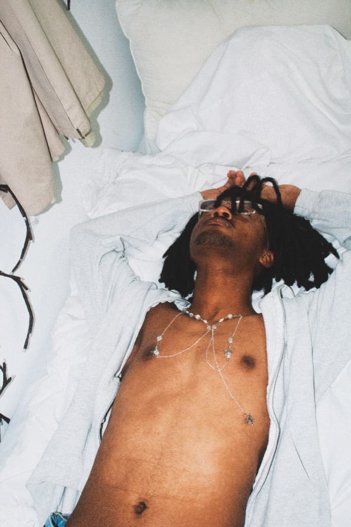 Lying across the bed wearing the silver crystal necklace
